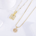 Initial necklace worn at the collarbone