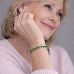 Emerald stone gold bracelet worn on wrist